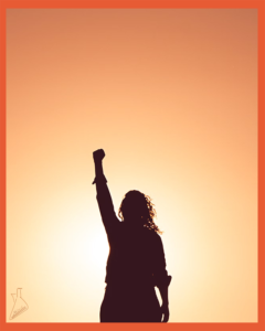زنی که پشت به آفتاب ایستاده و سایه‌‌ای از او در حالی که دستی را بالا برده و مشت کرده است در پس زمینه‌ی آسمانِ غرق در آفتاب دیده می‌شود. | عکاس: میگل برونا